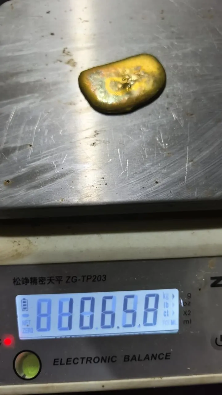 An alluvial gold nugget being weighed on an electronic balance